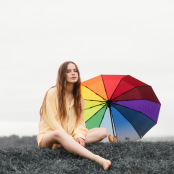 Artist Gabrielle Aplin with a rainbow umbrella 